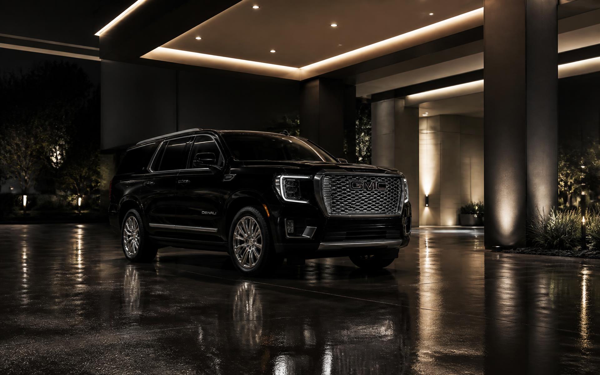 Black GMC Yukon XL Denali at a modern Las Vegas resort entrance at night